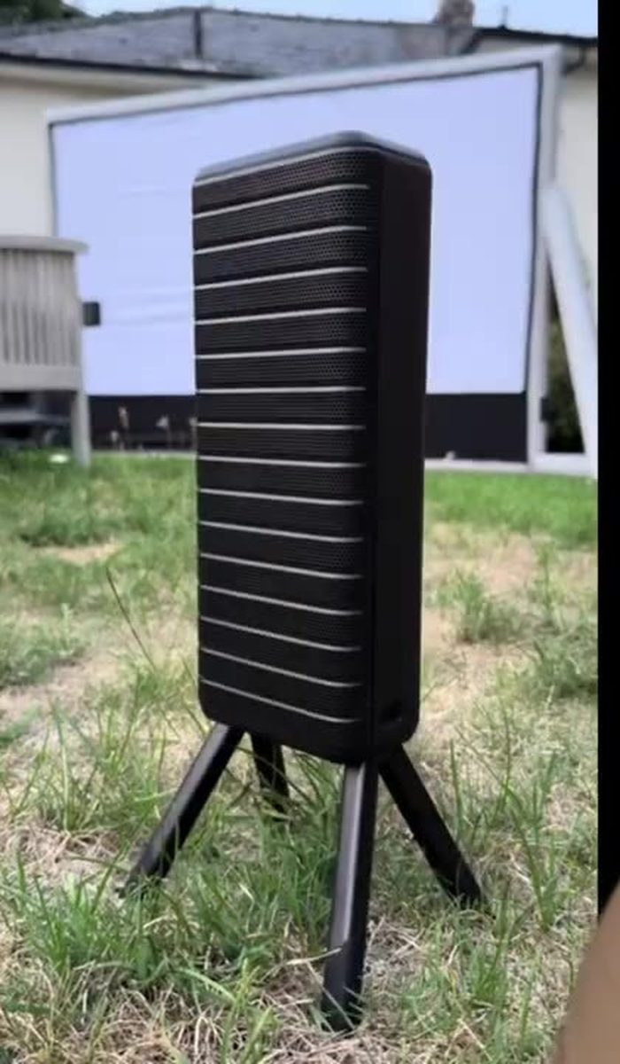 Detached X1 Pro speaker on tripod legs, inflatable screen behind