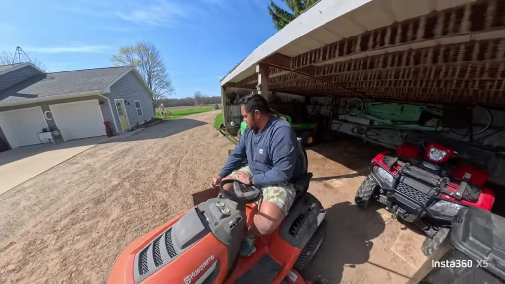 360 invisible-stick shot of a mower by the house and shed.
