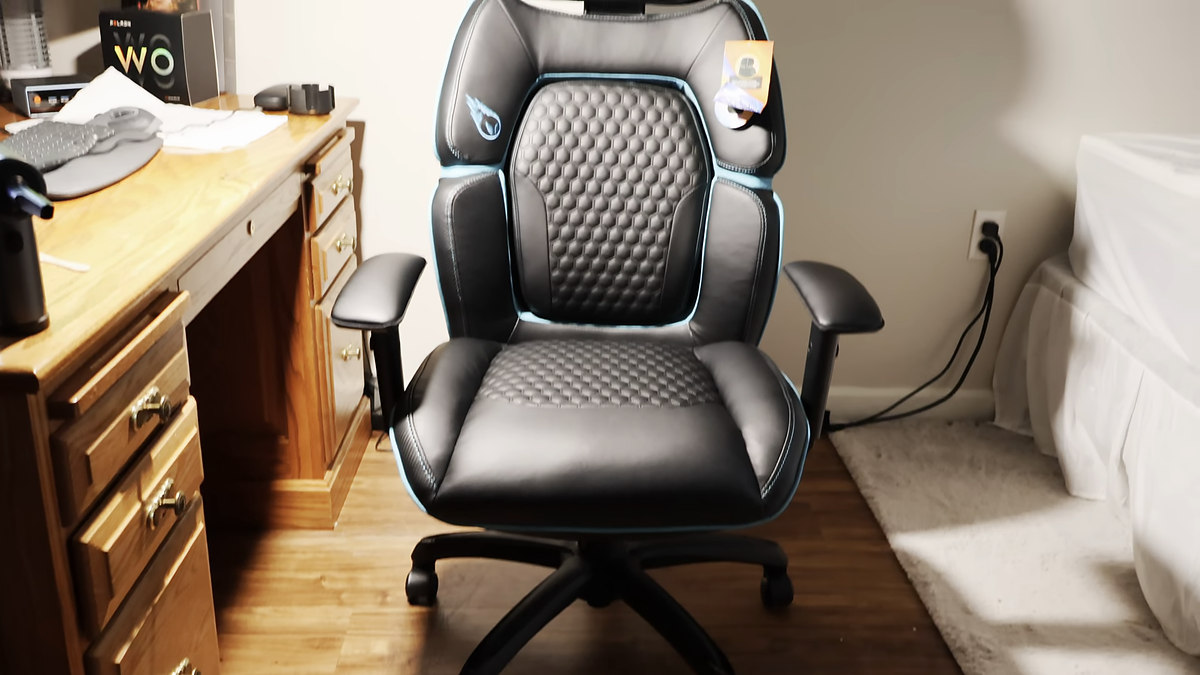 Black Costco DPS gaming chair with blue piping and honeycomb quilting standing empty — Costco compare only