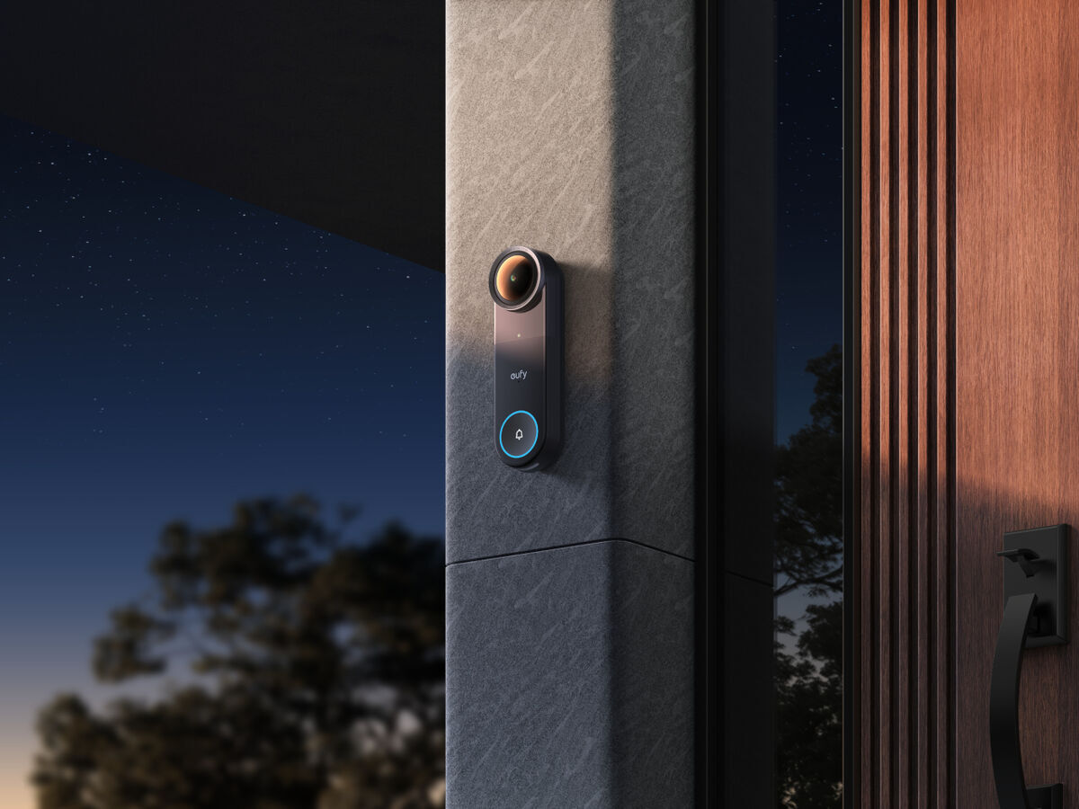 eufy Video Doorbell S4 mounted on stone pillar beside wooden door at night
