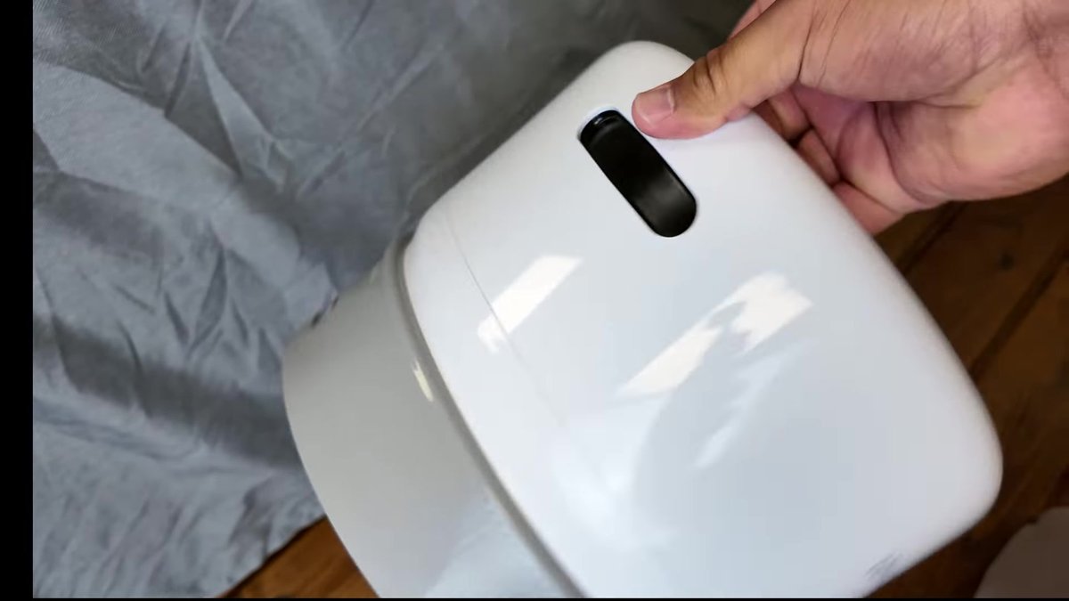 Hand holding the white Levoit Eleva 500X unit